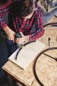overhead view of a man drilling a hole in to a partial piece of a&hellip;